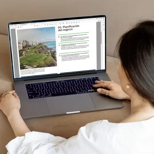 Chica usando una laptop con guía de BASE sobre planificación de negocios
